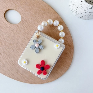 Detail of Galaxy Z Flip case with 3D floral accents and elegant pearl bead handle strap