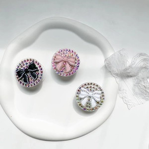 Close-up of sparkling rhinestone phone sockets featuring elegant black, pink, and white bows