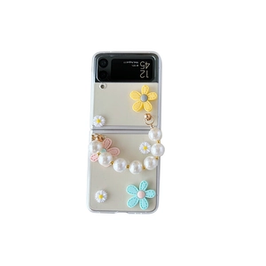 White Galaxy Z Flip case featuring 3D floral accents and a premium pearl bead handle strap