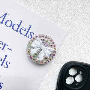 Macro shot of phone socket grip featuring a rhinestone bow and pearl bezel design