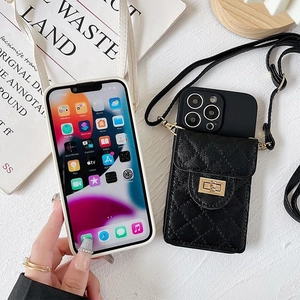 Detail of black quilted leather phone case with gold metal lock and shoulder strap