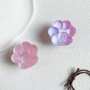 Detail van twee roze laser kattenpoot telefoonhouders met 3D-hart op witte achtergrond