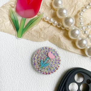 Detail of flower phone grip with rhinestones and pink tulip design on white background