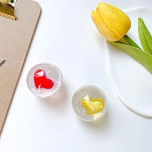 Detail of crystal heart phone grip socket with resin finish in red and yellow colors