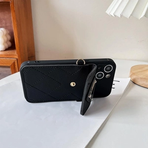 Close-up of black quilted leather phone case with metal ring holder and kickstand