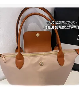 Detail of high-quality gold zipper and magnetic metal buckle on nylon tote bag