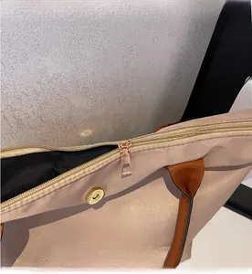 Detail of nylon travel tote featuring a smooth gold zipper and magnetic closure