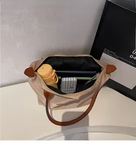 Macro detail of the spacious nylon tote bag interior with champagne gold finish and brown handle