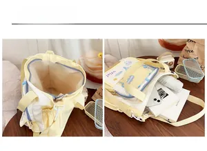 Detail showing spacious interior and compartments of yellow and white canvas tote bag