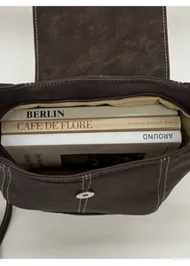 Vista interna che mostra la grande capacità e la fodera beige della borsa a secchiello marrone