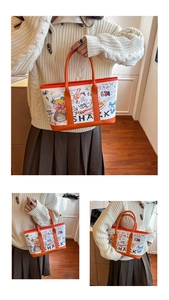 Detailed close-up of graffiti-style bucket bag with cartoon bear and orange leather handles