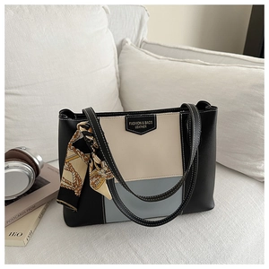 Detail of tricolor leather tote bag with silk scarf accent and fashion leather label