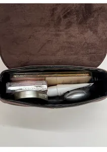 Interior view of small saddle bag showing storage space for phone and cosmetics