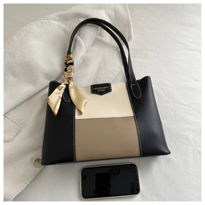 Detail of tricolor tote bag with silk scarf and logo plaque on a soft fabric base