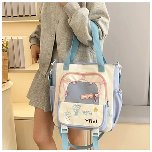 Détail du sac fourre-tout en toile bicolore avec broderie ballon et poche latérale élastique