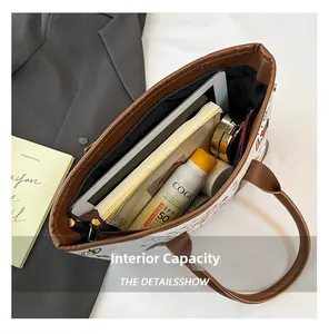 Spacious interior of white graffiti tote bag holding tablet, books and cosmetics