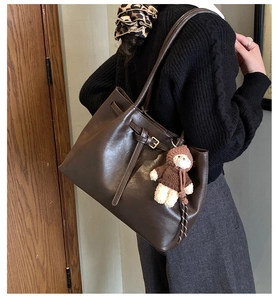Braune Vintage-Einkaufstasche mit Bärenanhänger am Modell als Größen- und Kapazitätsreferenz