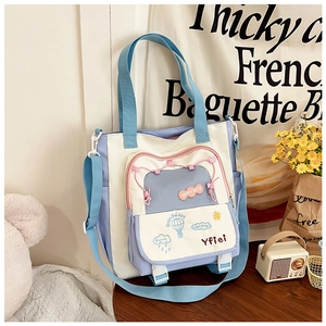 Détail du sac en toile bicolore avec illustrations mignonnes et poche avant à boucle