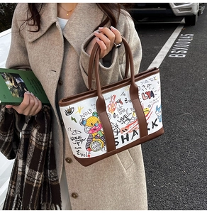 Détail du grand sac cabas avec graffitis de dessins animés et poignées en cuir marron