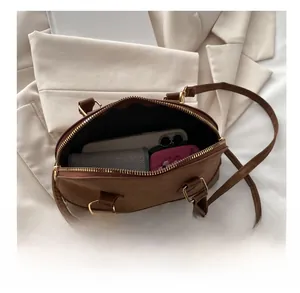 Top view of large capacity brown Boston bag interior with daily essentials and accessories