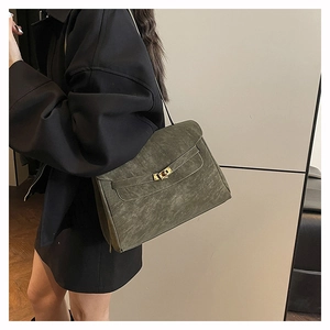Detail of dark green vintage suede trapezoid bag with golden metal turn-lock closure