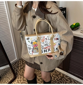 Detailed view of graffiti bucket bag with colorful bear prints and leather handles