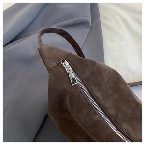 Detailed close-up of premium brown suede texture with durable silver metal zipper