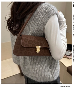 Détail du sac baguette vintage à motif léopard avec boucle dorée et bandoulière élégante