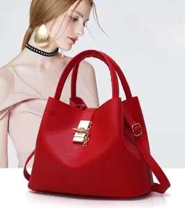 Macro detail of red lychee textured leather bag with elegant gold lock and chain