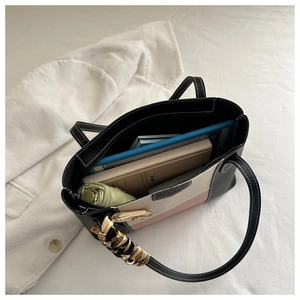 Internal capacity of tricolor tote bag showing umbrella and book storage detail