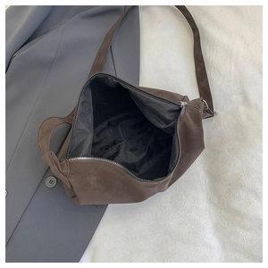 Detail view of the deep brown crossbody bag with zip closure and spacious interior