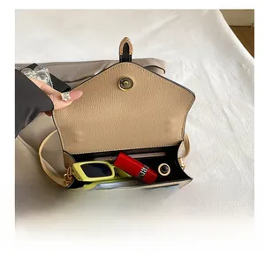Detailed interior of beige crossbody bag showing space for sunglasses and phone