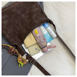Interior view showing the large capacity of the coffee suede tote bag with daily items