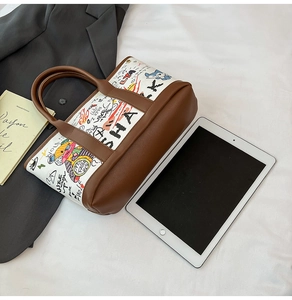 Détail du sac seau graffiti avec garniture en cuir et imprimés cartoon pour le bureau