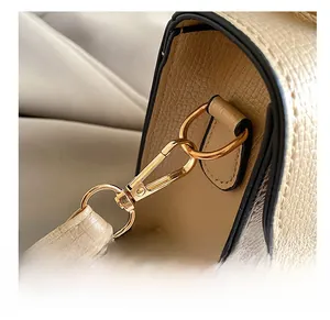 Detail of gold metal hook and lychee grain leather on a vintage beige handbag