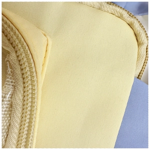 Detailed macro view showing the sturdy yellow oxford cloth texture and smooth zipper