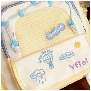 Detailed close-up of colorful embroidery and mesh pocket on the beige nylon tote bag