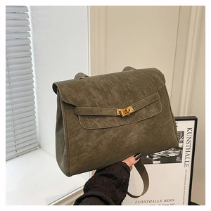Close-up of vintage textured leather handbag featuring a golden metal turn-lock closure
