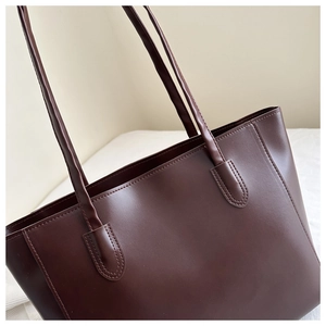 Detail of dark coffee PU leather tote bag with reinforced stitching and slim shoulder straps