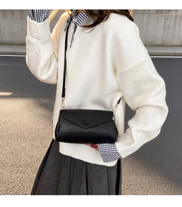 Fashionable black faux leather crossbody bag with lychee texture and round buckle
