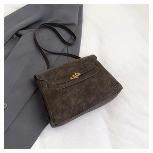Detail of grey suede messenger bag with gold twist lock and chic minimalist design