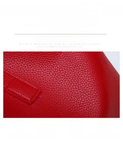 Detail of red lychee grain leather crossbody bag showing scratch-resistant material texture