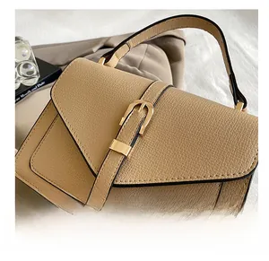 Detail of light coffee leather square bag with decorative metal buckle strap closure