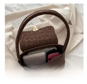 Détail intérieur du sac léopard montrant un téléphone, un portefeuille et des cosmétiques
