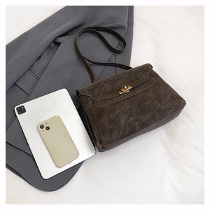 Detail of vintage gray textured leather crossbody bag with elegant gold metal twist lock