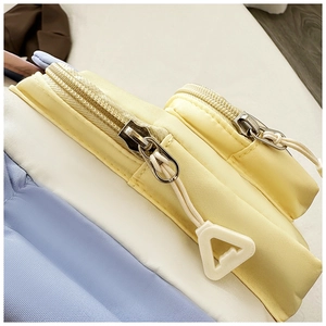 Detailed close-up of zipper and high-quality stitching on a multi-color nylon shoulder bag