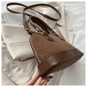 Detail of vintage brown shell bag showing suede splicing and golden zipper hardware