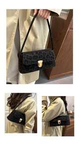 Detail view of black leopard print suede underarm bag with elegant gold metal buckle closure