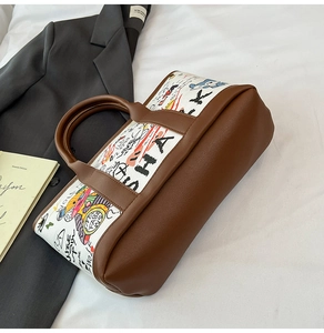 Détail d'un sac seau en toile avec graffitis colorés et poignées en similicuir marron