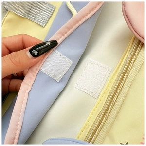 Detail of the multi-colored macaron fabric bag with velcro closure and interior zipper pocket